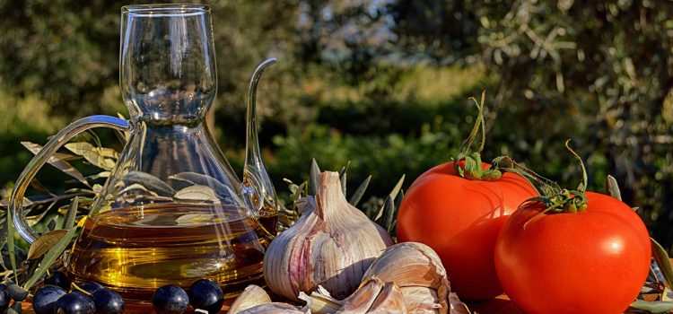 15 beneficios del aceite de oliva que valen su peso en oro Mesa con aceite de oliva virgen extra entre olivos
